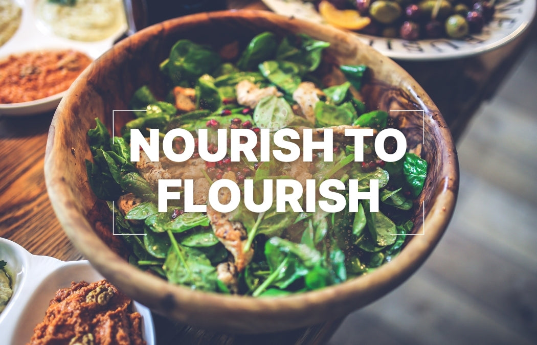 nourish to flourish text over a background of a chicken salad with pomegranates